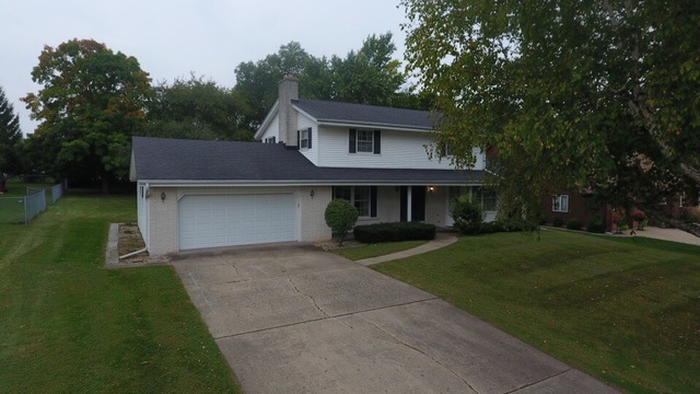 603 Old Orchard Road Harvard, IL 60033 - Photo 32 of 46 a front view of a house with a garden and trees