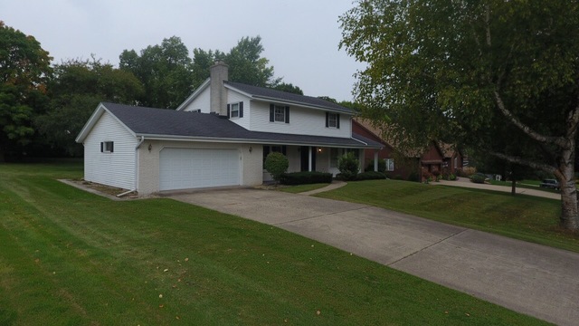 603 Old Orchard Road Harvard, IL 60033 - Photo 34 of 46 a front view of a house with a garden and yard