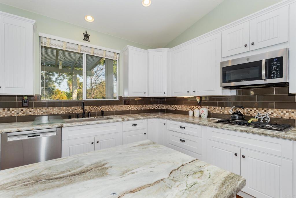 16350 Open View Road Ramona, CA 92065 - Photo 12 of 45 a kitchen with granite countertop white cabinets and appliances