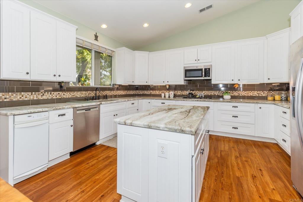 16350 Open View Road Ramona, CA 92065 - Photo 9 of 45 a kitchen with stainless steel appliances granite countertop a stove a sink and white cabinets