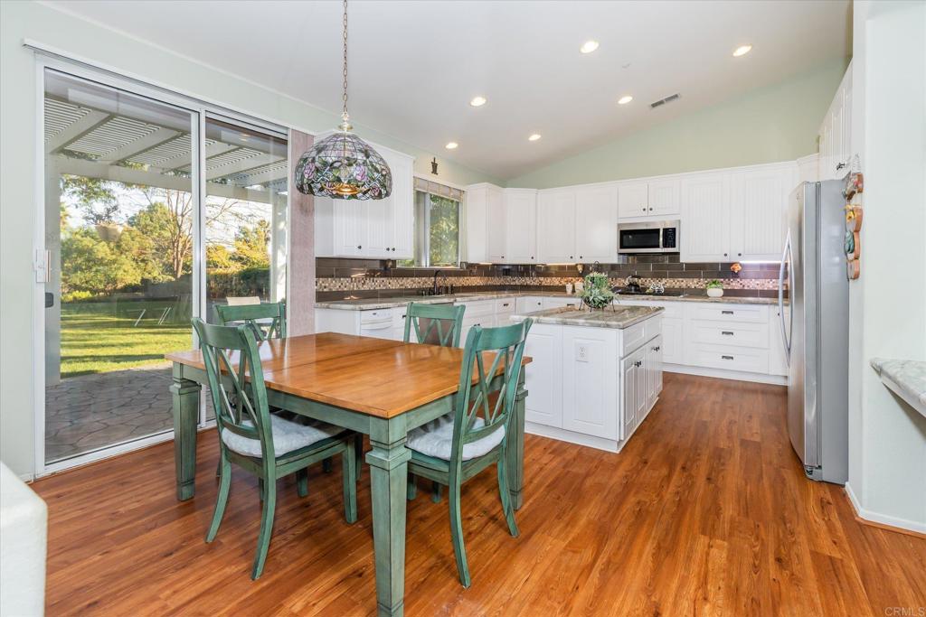 16350 Open View Road Ramona, CA 92065 - Photo 10 of 45 a kitchen with stainless steel appliances a dining table chairs and wooden floor