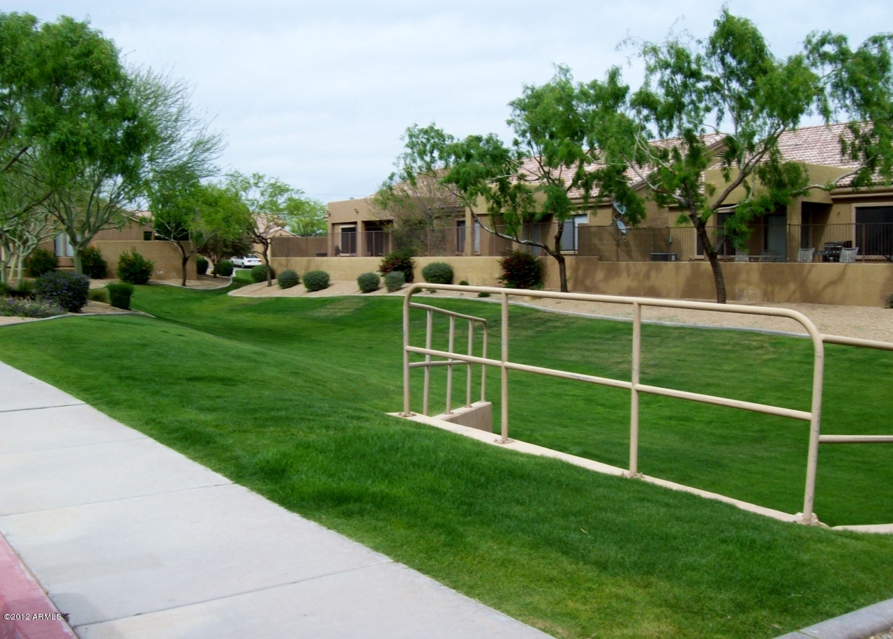 2565 South Signal Butte Road, Unit 39 Mesa, AZ 85209 - Photo 27 of 28 a front view of a house with a yard table and chairs