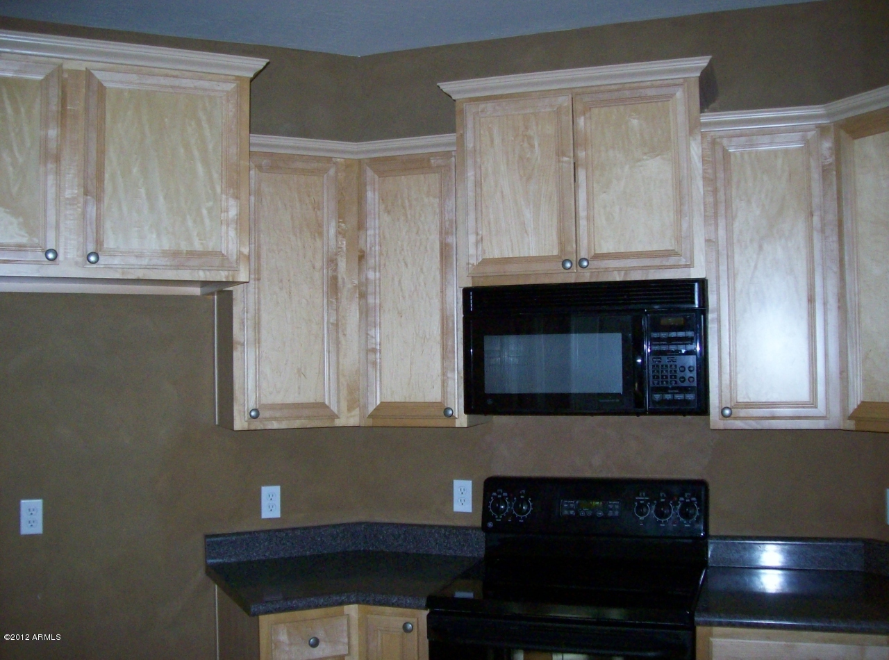 2565 South Signal Butte Road, Unit 39 Mesa, AZ 85209 - Photo 5 of 28 a kitchen with granite countertop white cabinets and black appliances