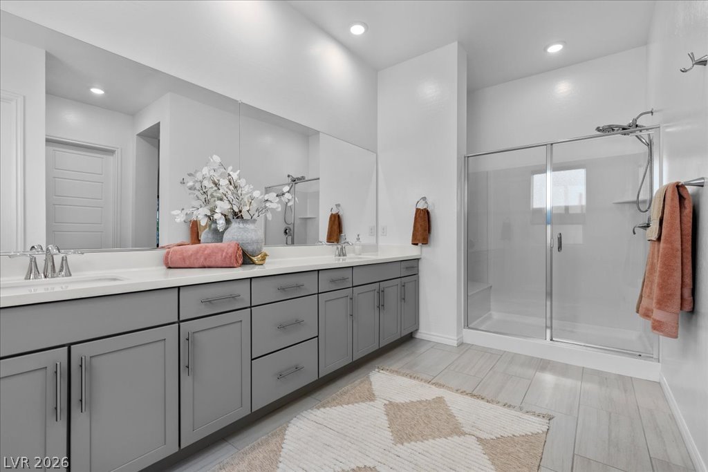 20 Charlotte Ridge Place Henderson, NV 89011 - Photo 22 of 33 A well-appointed primary bathroom showcases a long vanity, dual sinks, and a sleek walk-in shower.