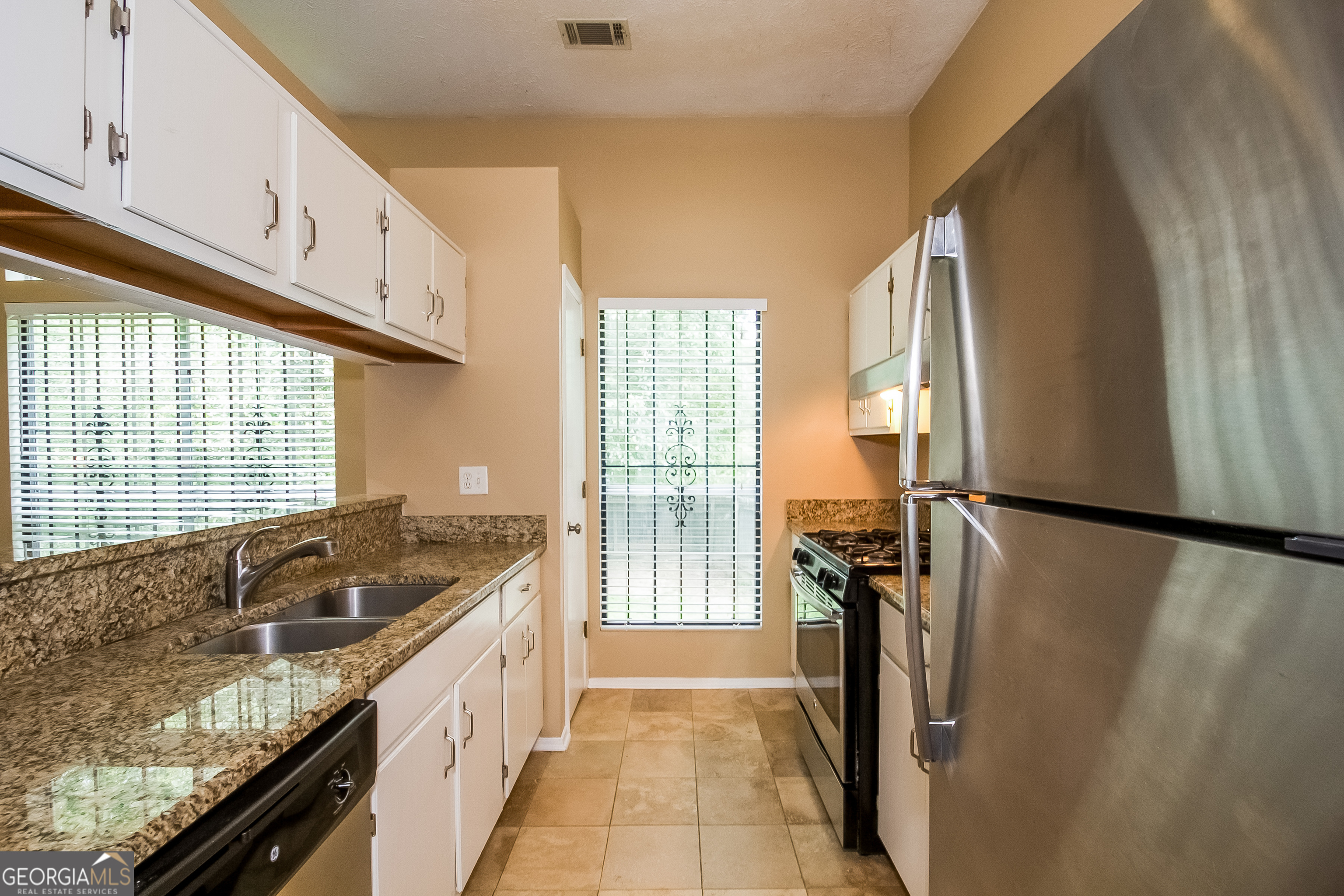 6350 Laurel Post Drive Lithonia, GA 30058 - Photo 5 of 15 a kitchen with granite countertop a refrigerator and a sink
