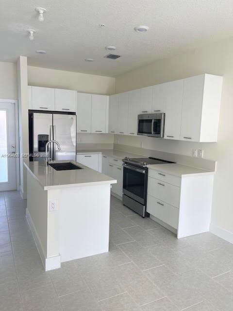 8167 Northwest 41st Street, Unit E111 Doral, FL 33166 - Photo 3 of 14 a kitchen with kitchen island a sink stainless steel appliances and cabinets