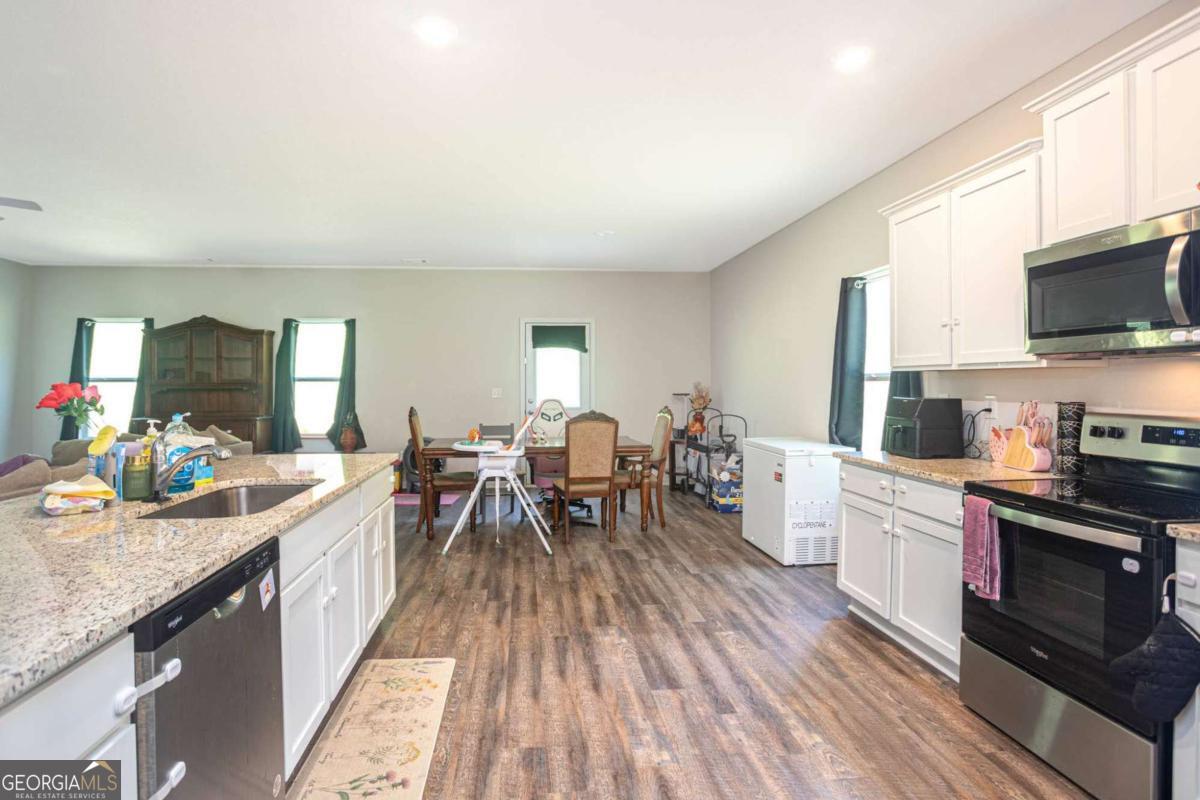 653 Meadows Farm Way Monroe, GA 30655 - Photo 15 of 34 a large kitchen with a table and chairs in it