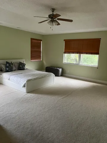 a bedroom with a bed and a chandelier fan
