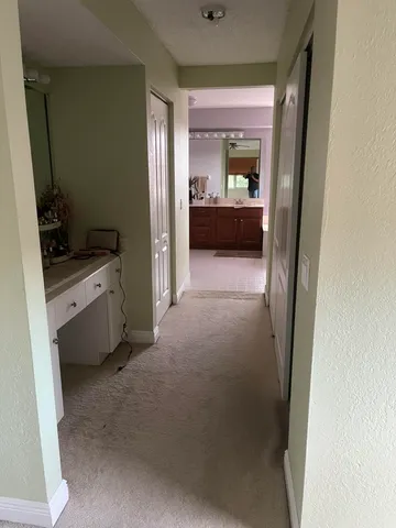a view of a hallway and a livingroom with furniture