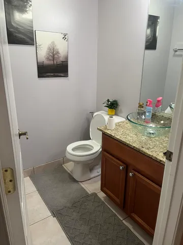 a bathroom with a granite countertop toilet and a sink