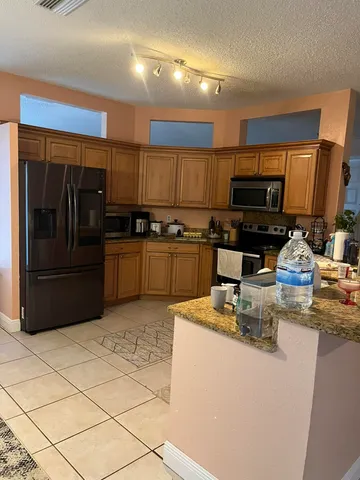 a kitchen with stainless steel appliances granite countertop a stove a sink and a refrigerator