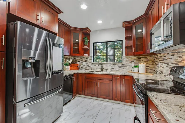 a kitchen with stainless steel appliances granite countertop a refrigerator and a sink