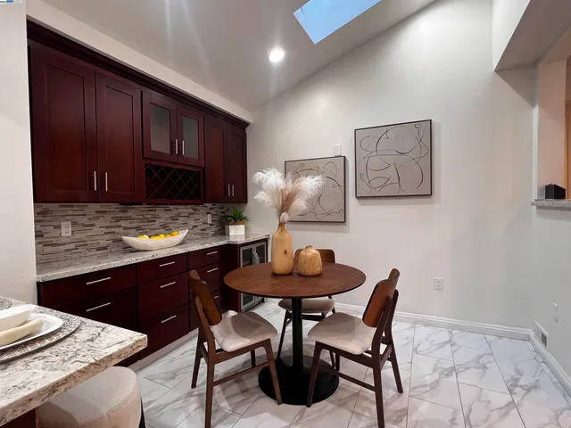 a kitchen with granite countertop a table chairs a sink and cabinets