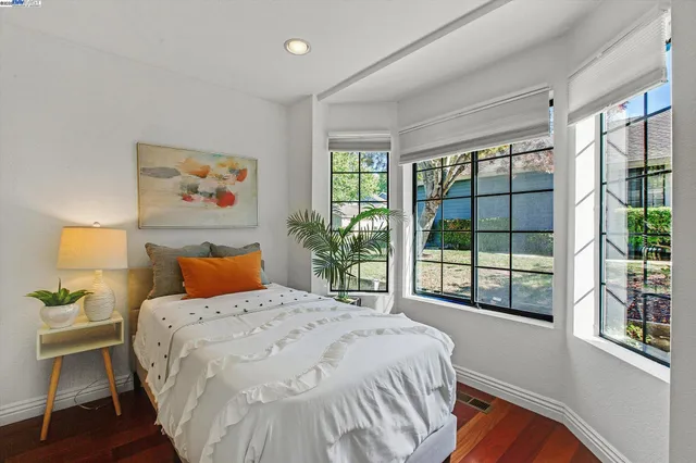 a bedroom with a bed and a large window
