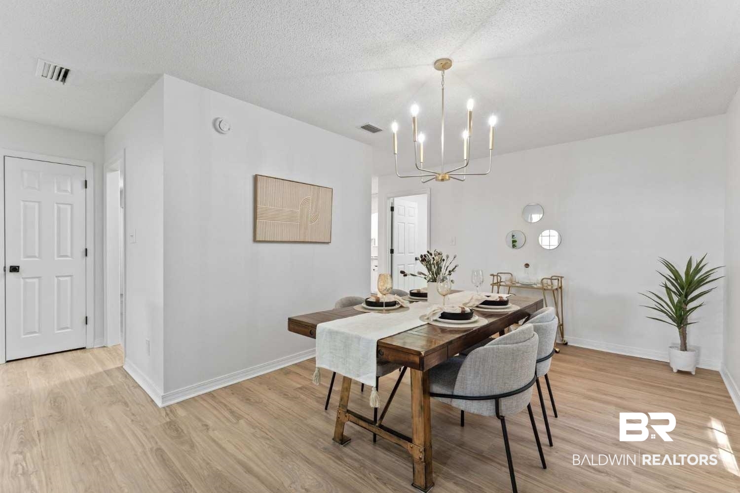10251 Windmill Road Fairhope, AL 36532 - Photo 19 of 44 Dining area with a chandelier, light wood-type flooring, and a textured ceiling
