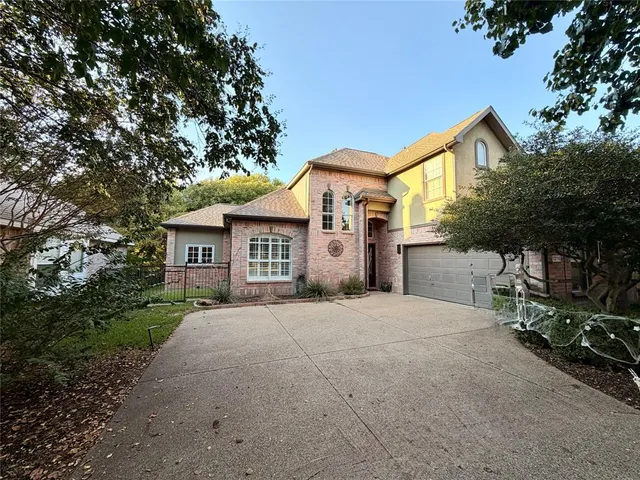 a front view of a house with yard and trees