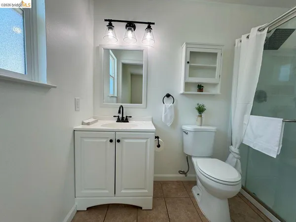 a bathroom with a sink a toilet a mirror and shower