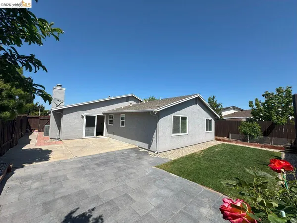 a view of a house with a yard and potted plants