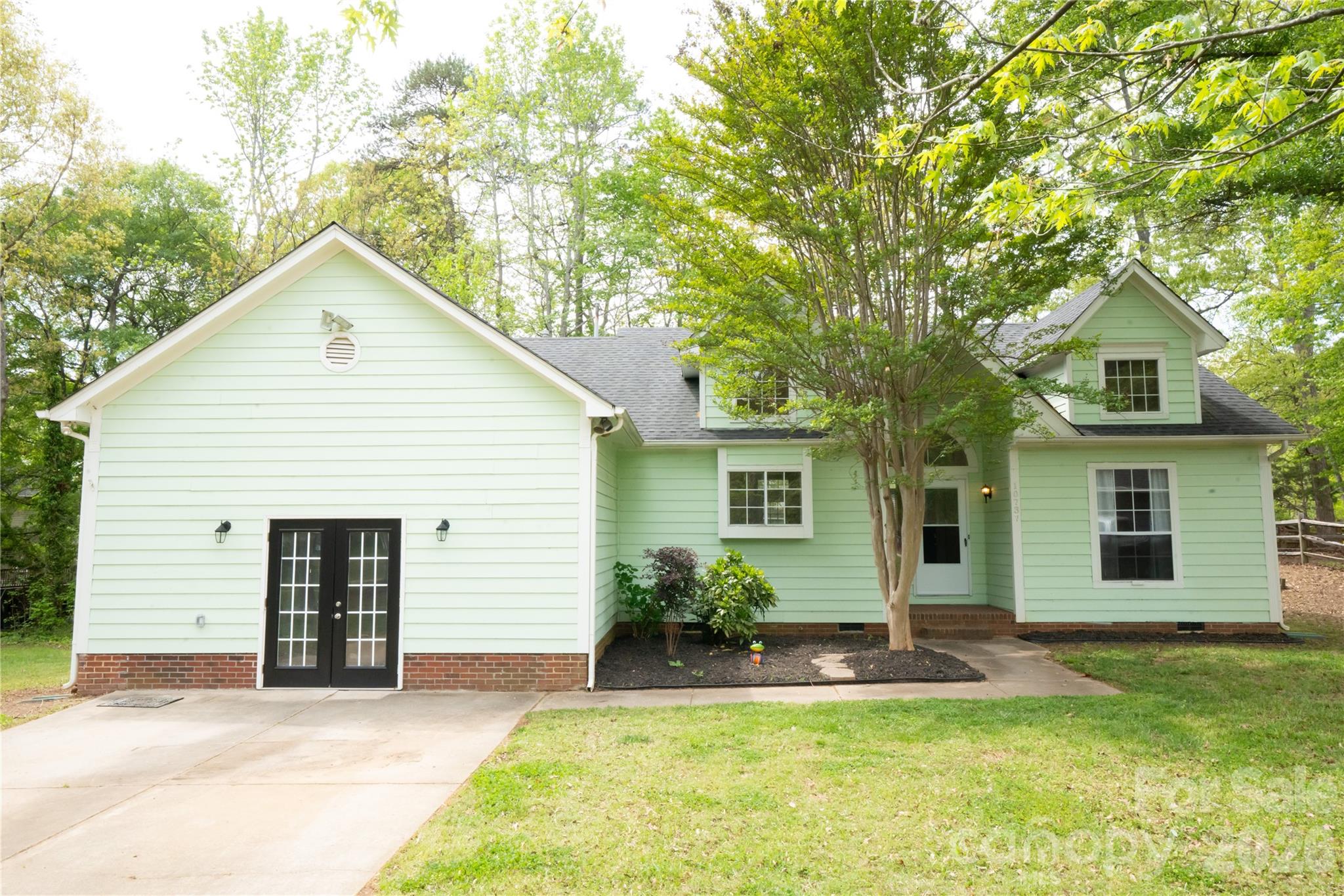 a view of a house with a patio and a yard
