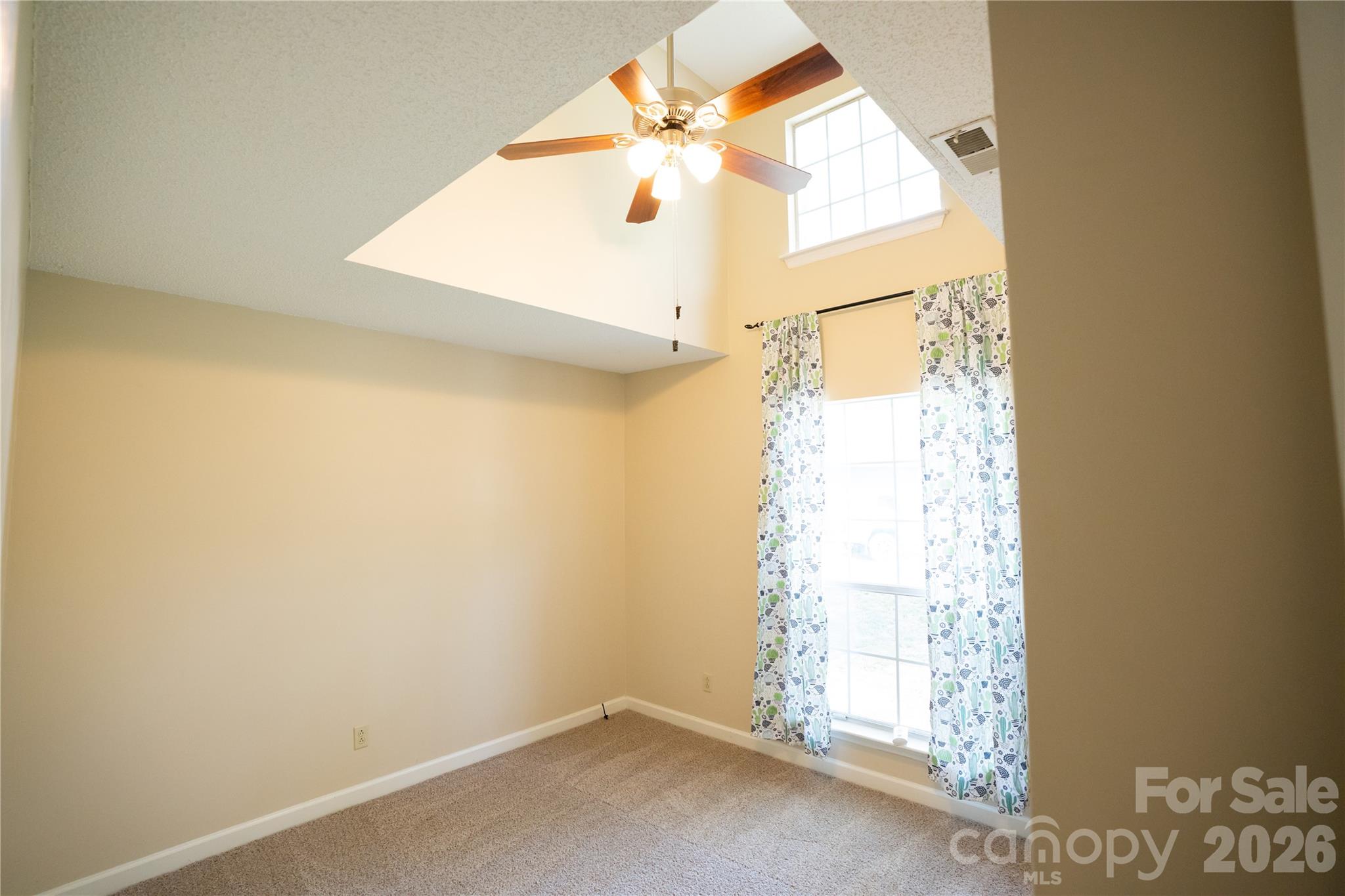 10737 Spruce Mountain Road Charlotte, NC 28214 - Photo 11 of 19 an empty room with windows and a ceiling fan