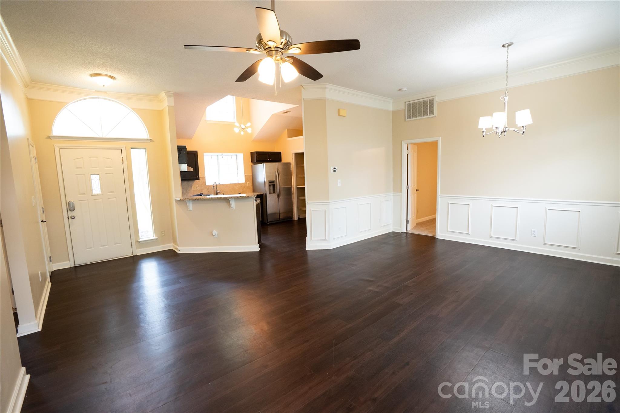 10737 Spruce Mountain Road Charlotte, NC 28214 - Photo 3 of 19 an empty room with wooden floor fan and windows