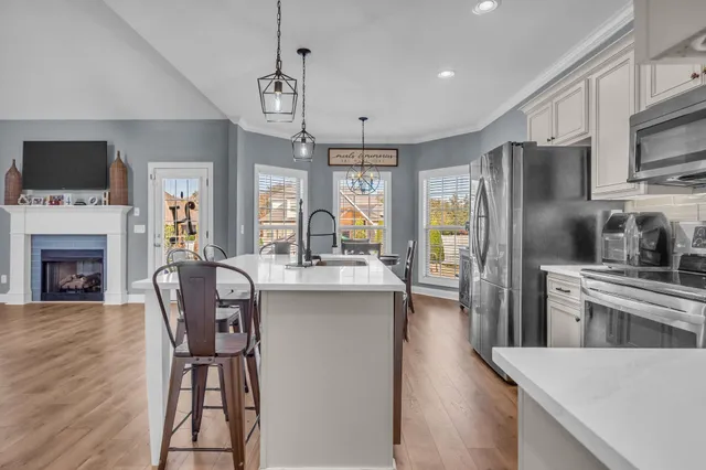 a kitchen with stainless steel appliances granite countertop a stove a microwave a sink a stove a dining table and chairs