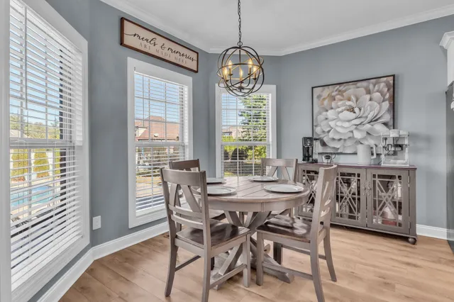 a kitchen with stainless steel appliances kitchen island granite countertop a refrigerator a stove a sink and white cabinets