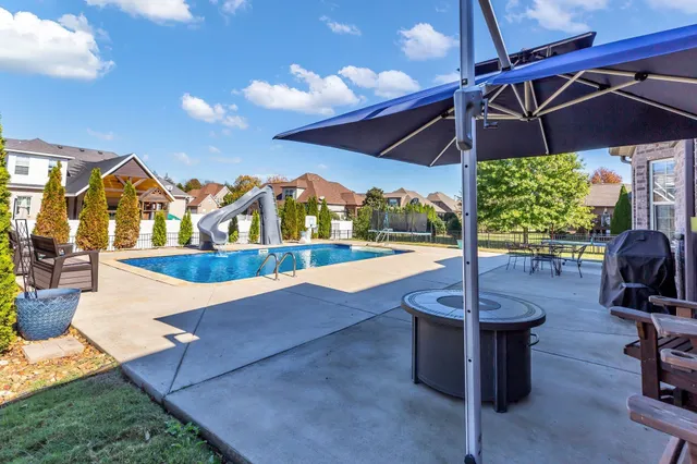 a view of swimming pool with outdoor seating and a garden
