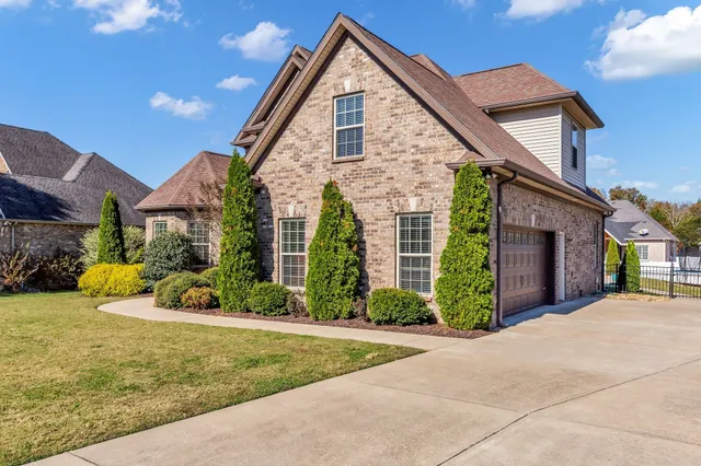 a front view of a house with a yard and potted plants