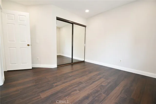 an empty room with wooden floor and closet