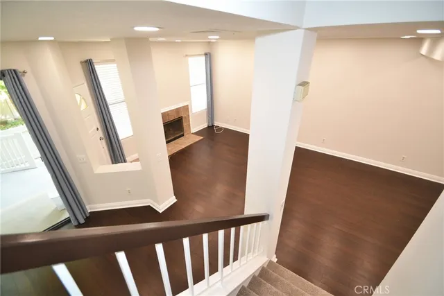 a view of a hallway with wooden floor and stairs