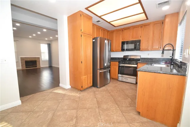 a kitchen with stainless steel appliances granite countertop a refrigerator a stove top oven a sink and dishwasher