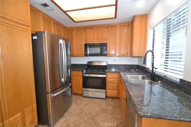 a kitchen with granite countertop a refrigerator and a sink