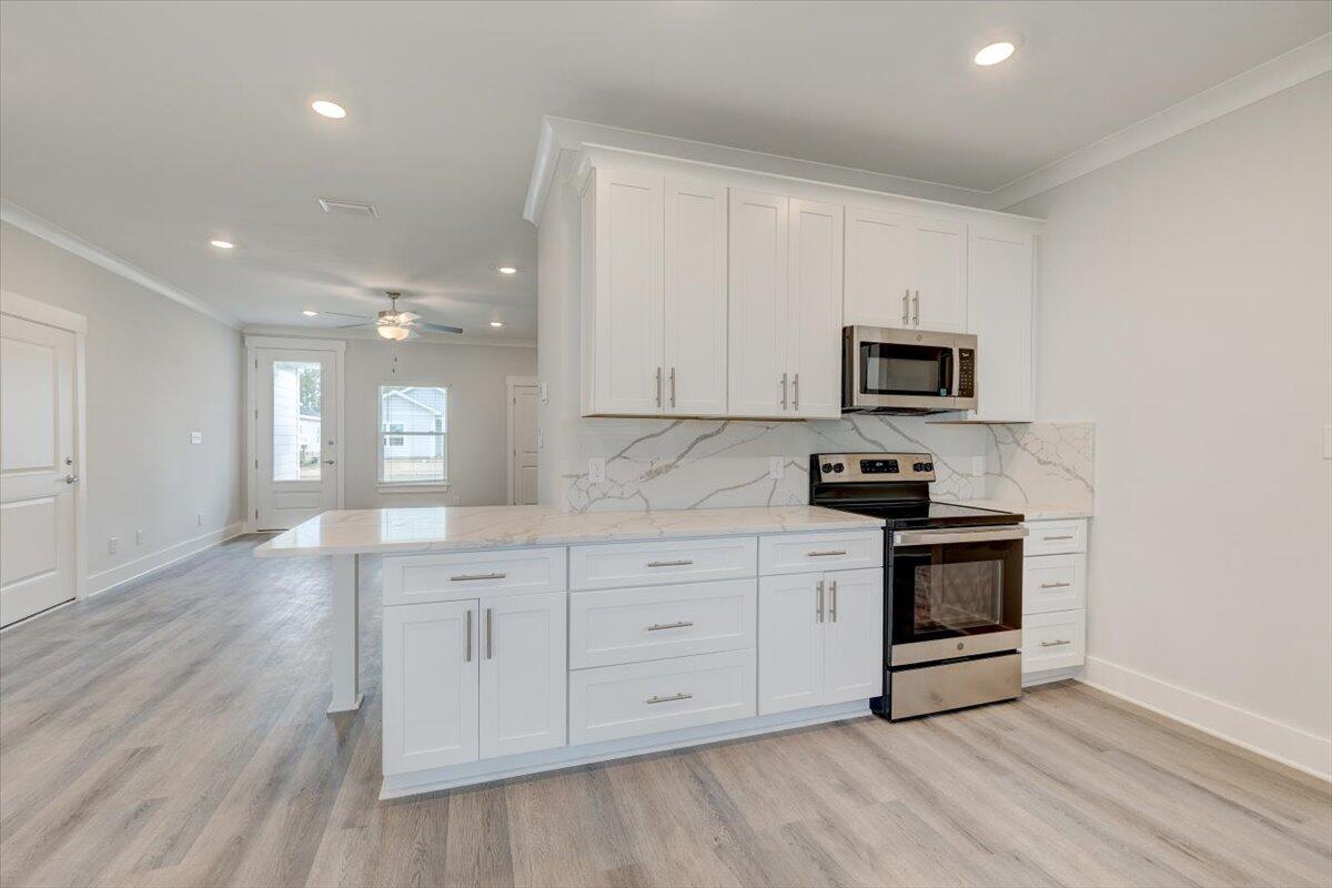 14 Alexander Way Freeport, FL 32439 - Photo 12 of 25 a kitchen with stainless steel appliances granite countertop a stove a sink and white cabinets