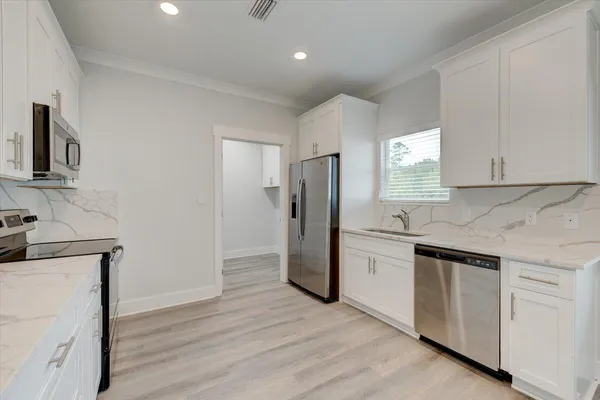 a kitchen with a refrigerator sink and cabinets