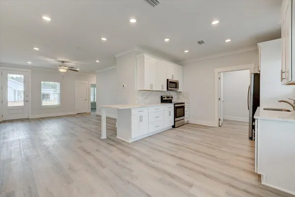 a view of a kitchen with a sink and a refrigerator