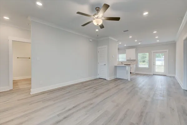 a view of an empty room and a kitchen