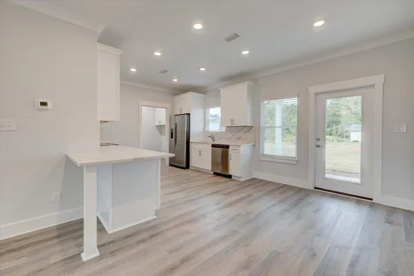 a view of kitchen with wooden floor and electronic appliances