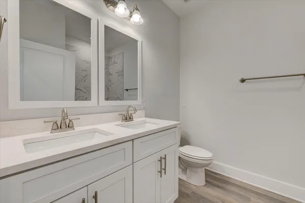 a bathroom with a toilet a sink and mirror