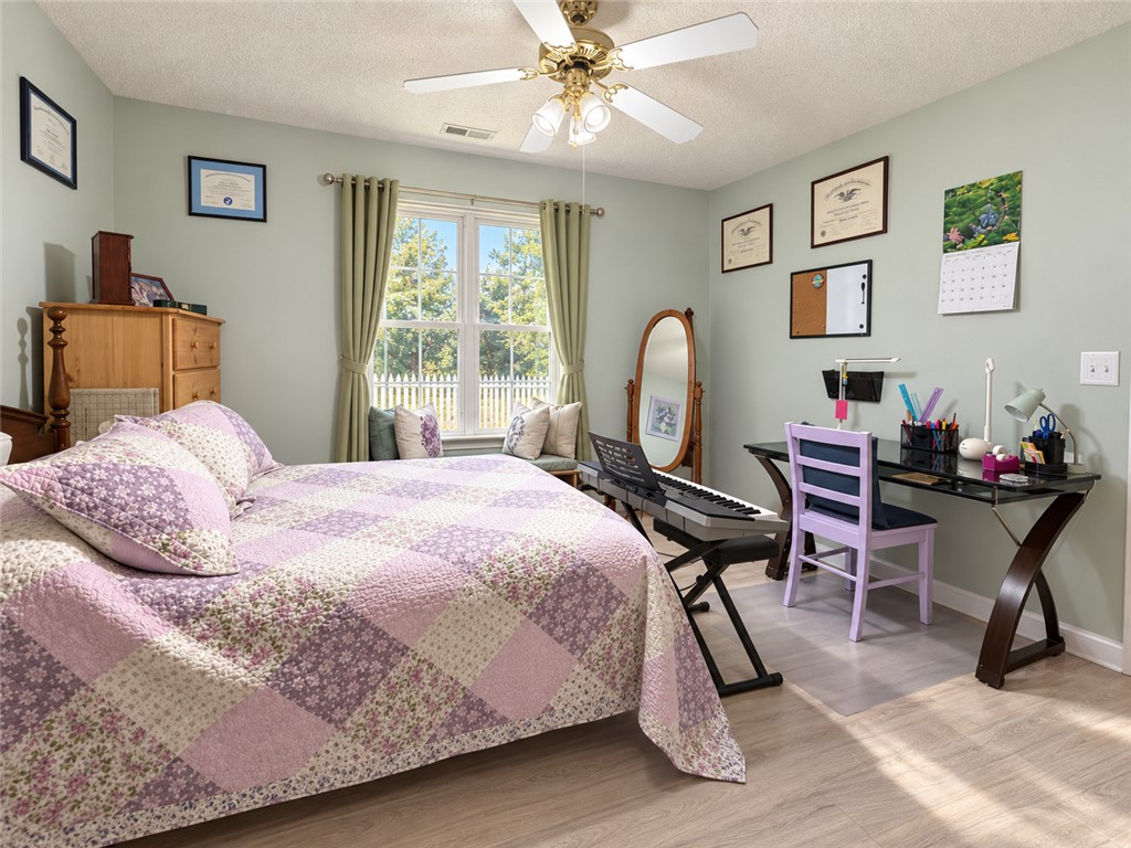 113 Grand Oak Circle Pendleton, SC 29670 - Photo 11 of 25 Smooth wood-look flooring and a wide window with backyard views anchor this versatile secondary bedroom.
