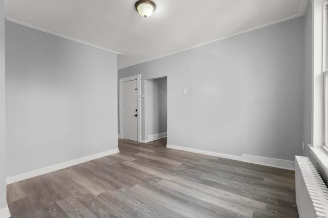 a view of an empty room with wooden floor