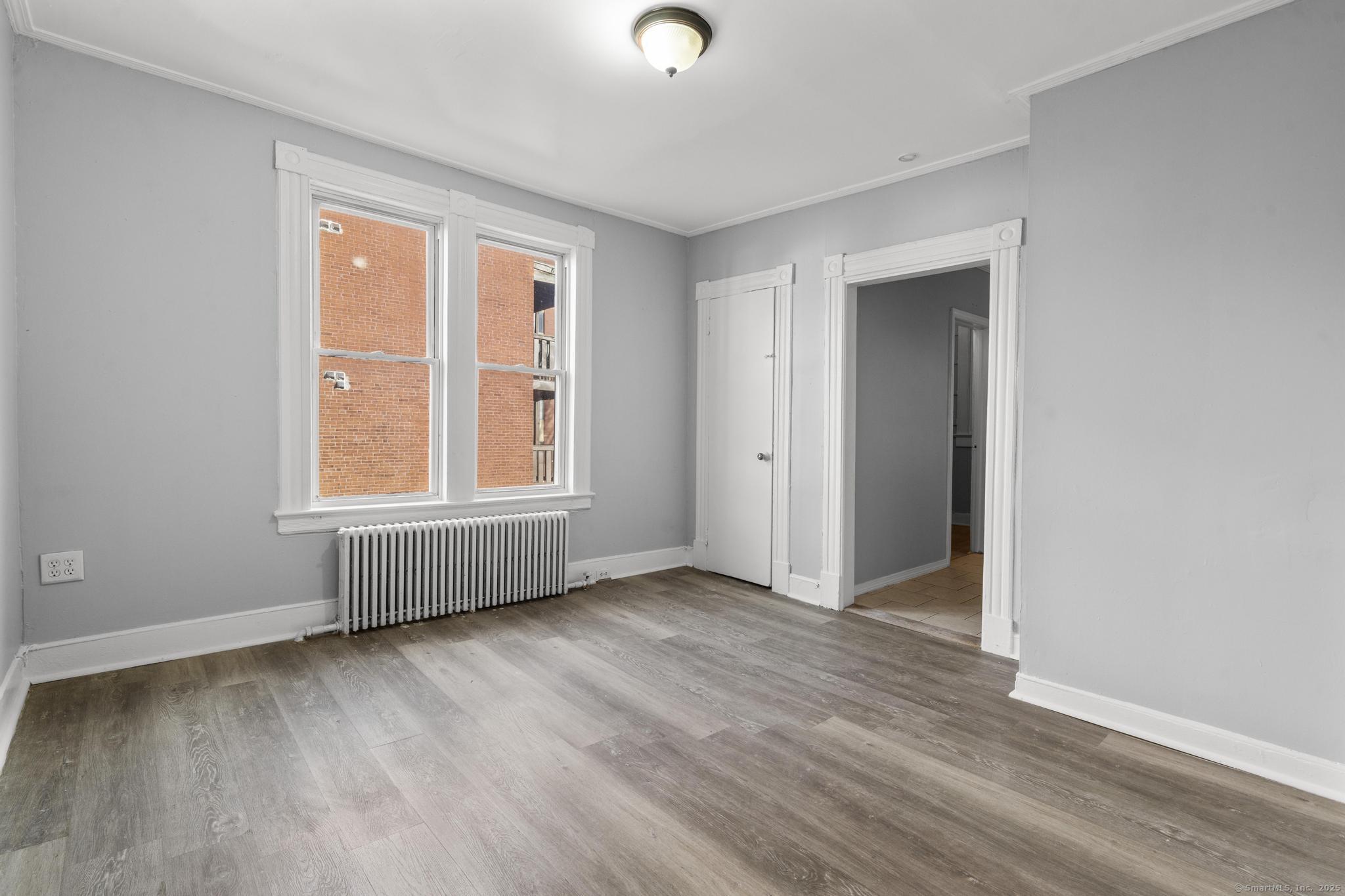 19 Whitmore Street Hartford, CT 06114 - Photo 13 of 27 an empty room with wooden floor and windows