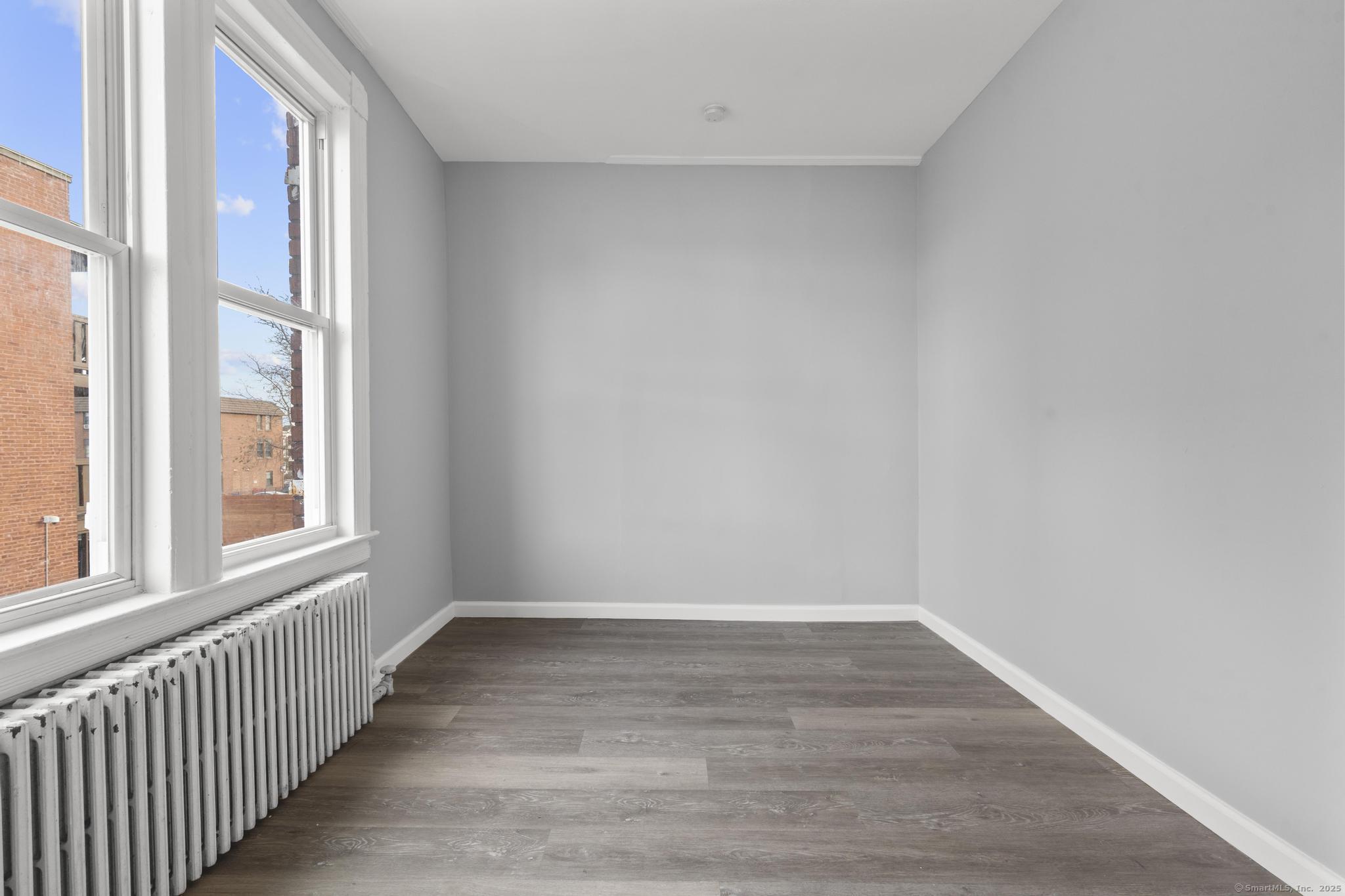 19 Whitmore Street Hartford, CT 06114 - Photo 17 of 27 a view of an empty room with wooden floor and a window