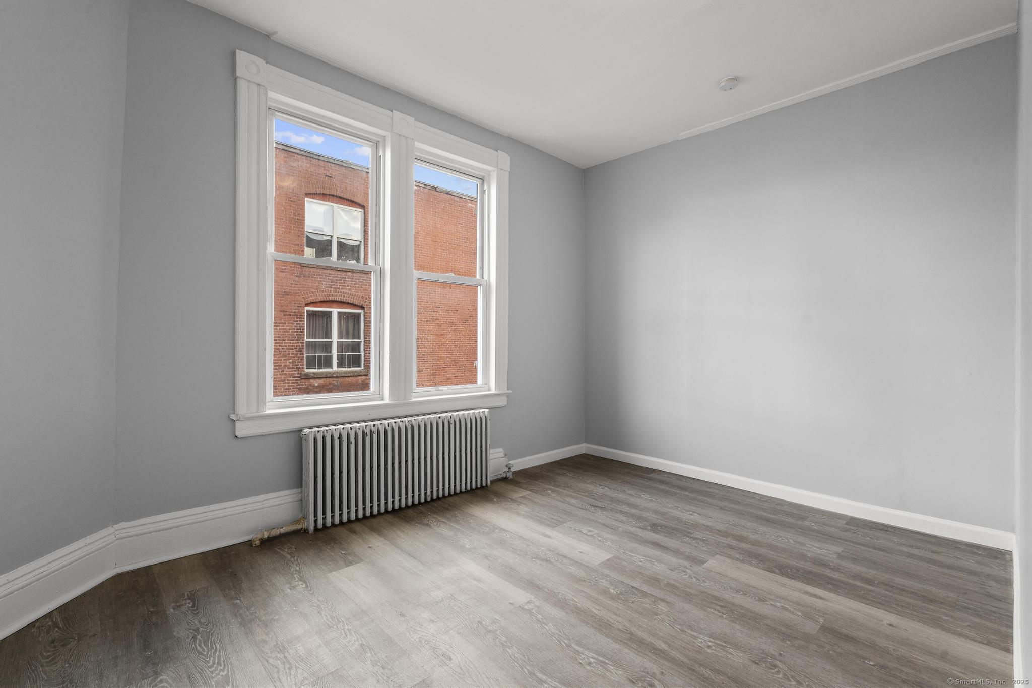 19 Whitmore Street Hartford, CT 06114 - Photo 18 of 27 an empty room with wooden floor and windows