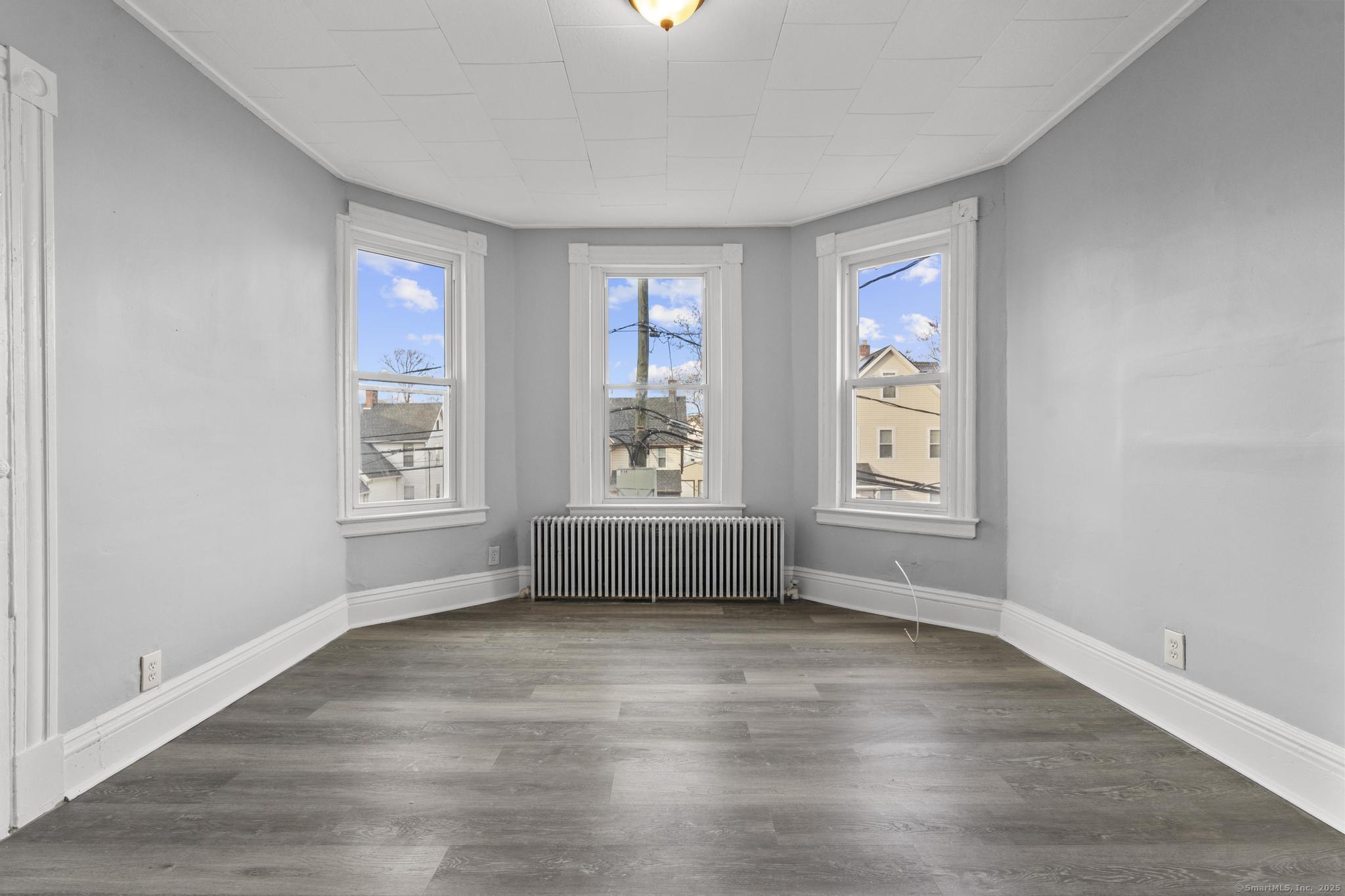 19 Whitmore Street Hartford, CT 06114 - Photo 20 of 27 an empty room with wooden floor and windows