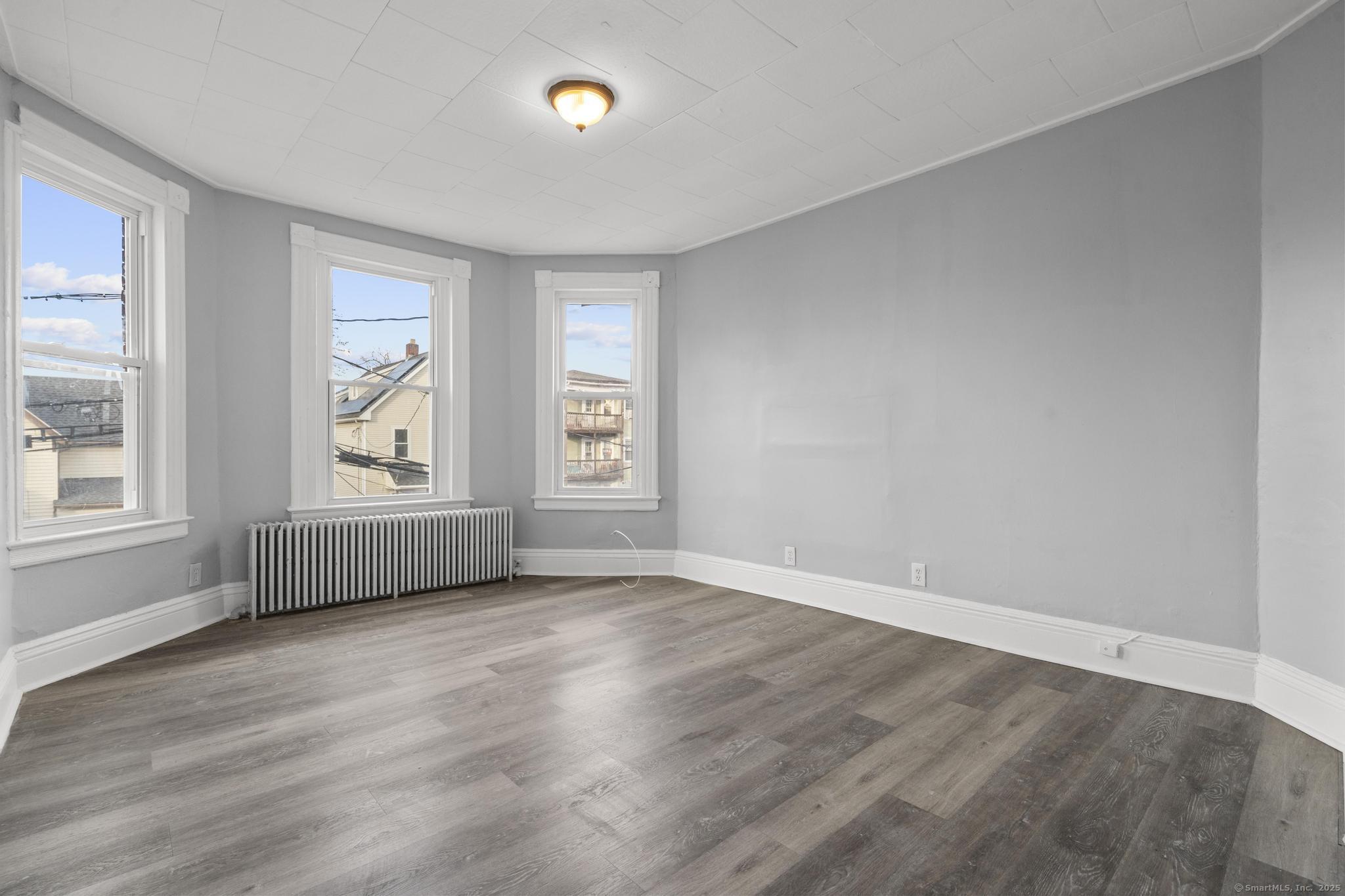 19 Whitmore Street Hartford, CT 06114 - Photo 21 of 27 an empty room with wooden floor and windows
