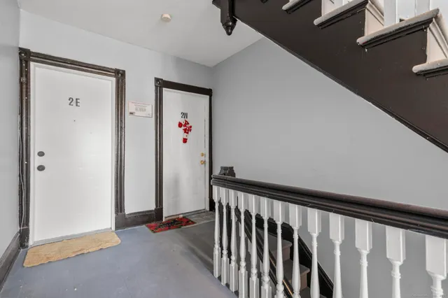 a view of a hallway with wooden floor and closet