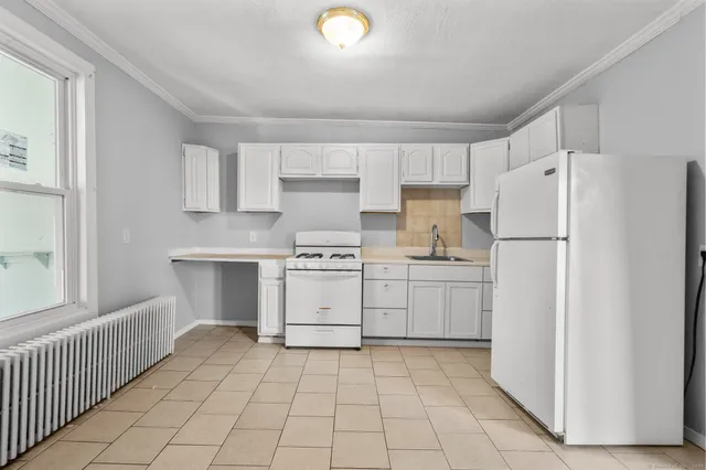 a kitchen with white cabinets and white appliances
