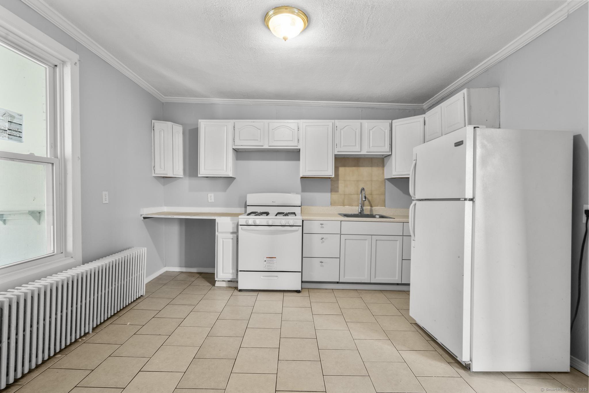 19 Whitmore Street Hartford, CT 06114 - Photo 3 of 27 a kitchen with white cabinets and white appliances