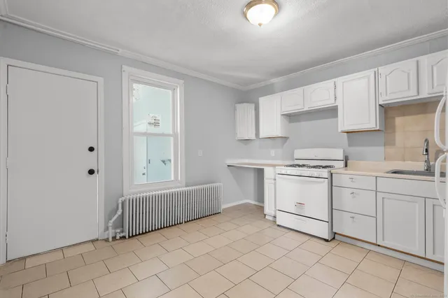 a kitchen with white cabinets a sink and dishwasher